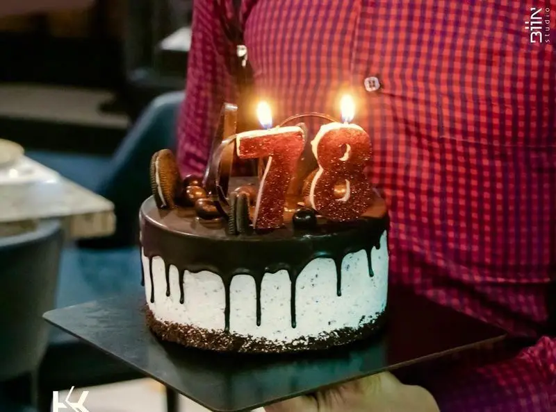 جشن تولد باشکوه با کیک تولد 78 سالگی در کافه رستوران کالوک، کیکی زیبا با تزئین شکلات و اورئو و شمع‌های روشن.