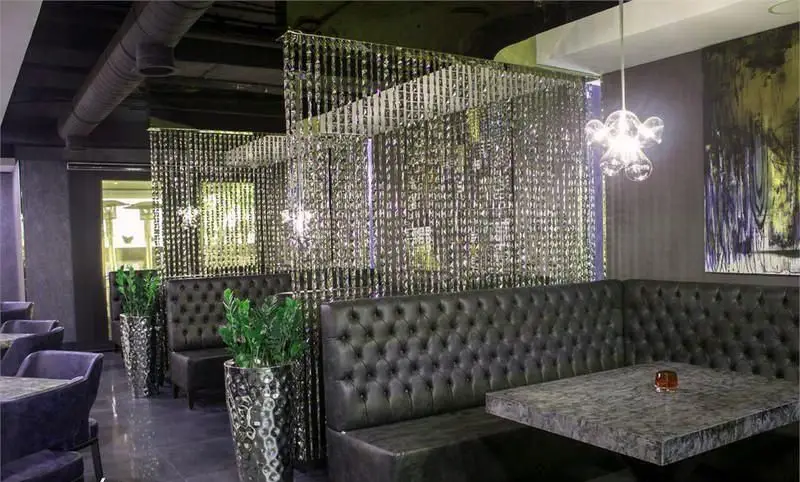 دکوراسیون داخلی شیک کافه رستوران کالوک با مبلمان چرمی، پرده‌های کریستالی و نورپردازی مدرن، فضایی لوکس و دلپذیر.