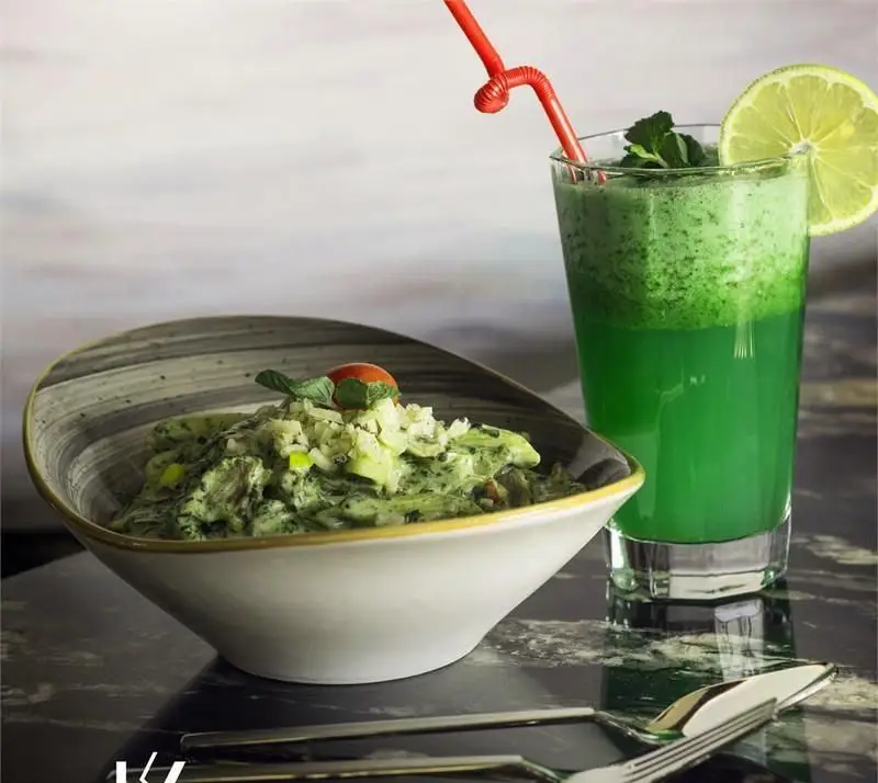 پاستای سبز خوشمزه کافه رستوران کالوک با سس خامه ای و تاپینگ، در کنار اسموتی تازه و سالم لیمو نعنا.