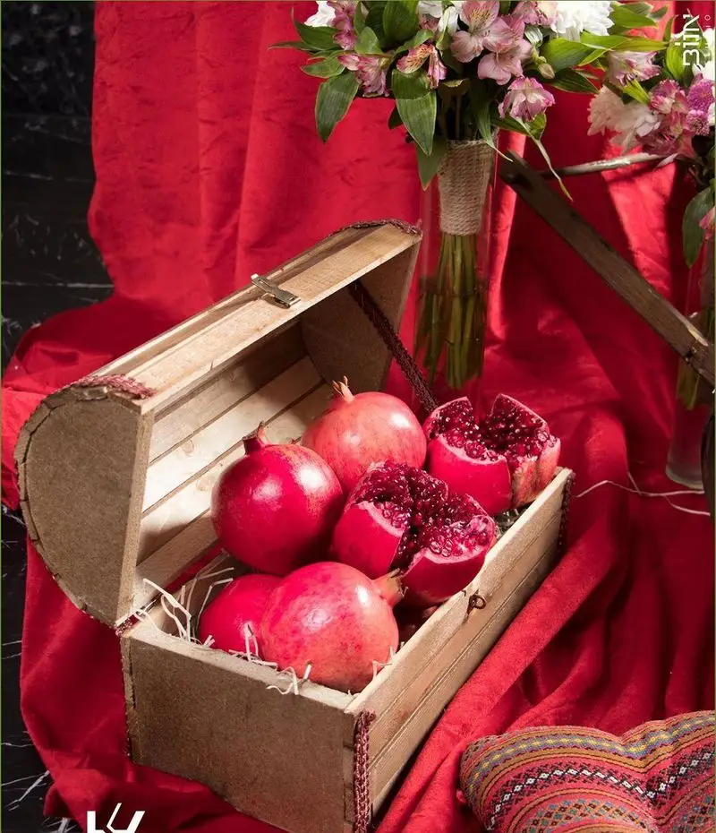 تصویری زیبا از انارهای تازه و دانه شده در صندوقچه چوبی، بخشی از دکوراسیون خاص کافه رستوران کالوک با محیطی دلنشین و گرم.