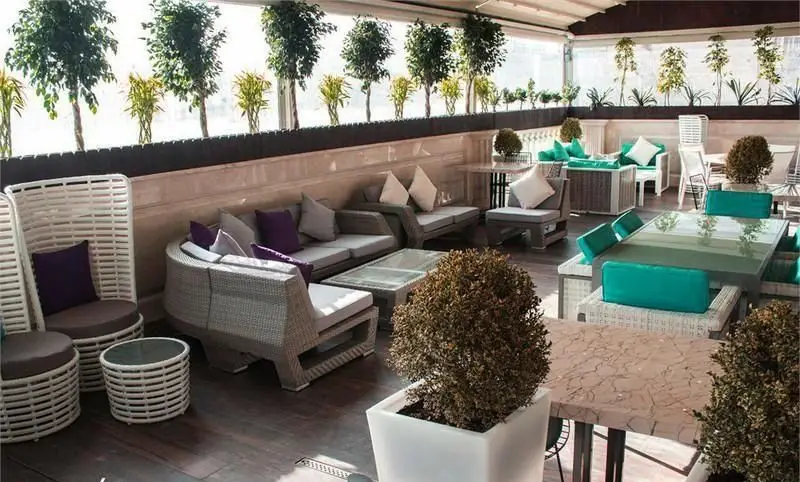 فضای باز روف گاردن کافه رستوران کالوک با دکوراسیون مدرن، مبلمان شیک و راحت، و درختان زیبا برای استراحتی دلپذیر.