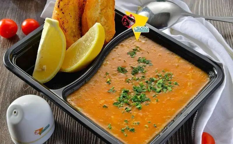 خانه کوچک: خورش یا سوپ داغ و لذیذ ایرانی با تزیین سبزی تازه، برش‌های لیمو و نان برشته در بسته بندی بیرون بر.