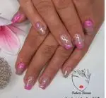 طراحی ناخن فشن با رنگ صورتی و نقره‌ای توسط سالن زیبایی بهاره بمان، الهام گرفته از مد روز.