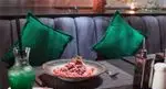دکوراسیون داخلی جذاب رستوران سینسره با میز آماده سرو، شامل نوشیدنی سبز و غذایی مدرن و خوش‌طعم. محیطی آرام و دلپذیر.