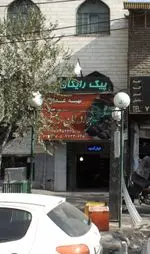 تصویر نمای خیابانی از تهیه غذای برادران رحمتی در تهران با تابلوی پیک رایگان، شماره تماس ۷۷۳۳۰۶۴۸ و ۷۷۳۳۰۶۴۵، عرضه کننده انواع کباب و غذای ایرانی.