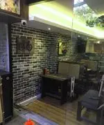 فضای داخلی دنج و مدرن کافی شاپ 4 چوب با دیوارهای آجری تیره، میز و صندلی‌های چوبی شیک و نورپردازی دلنشین برای تجربه‌ای خاص.