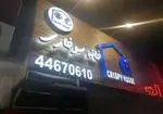 تصویر تابلوی درخشان رستوران فست فود خانه سوخاری (Crispy House) در شب با لوگو و شماره تلفن 44670610 برای سفارش غذا.