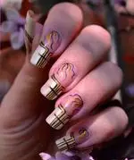 مانیکور طراحی شده با طرح هندسی و خطوط طلایی و مشکی، جلوه‌ای شیک و مدرن به ناخن‌ها می‌بخشد.