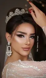 آرایش عروس خیره‌کننده با میکاپ چشم گربه‌ای، شینیون ژورنالی و تاج درخشان، خدمات سالن زیبایی پرسفید.