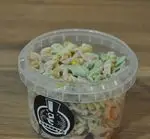 نمای نزدیک از سالاد ماکارونی کافه دندی با پاستاهای رنگی، ذرت و مواد متنوع در ظرف یکبار مصرف شفاف، مناسب وعده اسنک و قهوه.