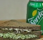 یک ساندویچ گریل شده سالم و لذیذ از کافه دندی با نان تیره و مواد تازه، به همراه نوشیدنی خنک اسپریت.