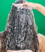 اعمال ماسک موی مغذی و درمانی بر روی موهای بلند و تیره در سالن زيبايي ژوتم هال برای احیا و تقویت مو، تضمین سلامت و زیبایی.