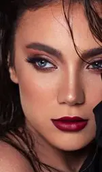 تصویری جذاب از مدل آرایش حرفه‌ای صورت، با رژ لب زرشکی تیره و چشم‌های آبی خیره کننده در سالن زیبایی ژوتم هال برای خدمات میکاپ و زیبایی.