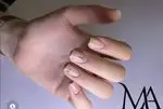 تصویری از طراحی ناخن شیک و مینیمال با ژلیش کالباسی و دیزاین ریز هندسی و متنی در سالن تخصصی ناخن مانیل.