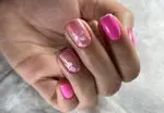 کاشت و طراحی ناخن جدید و شیک با گل‌های صورتی و سفید در آرایشگاه زنانه آنا. ایده‌های بهاری برای دیزاین ناخن.