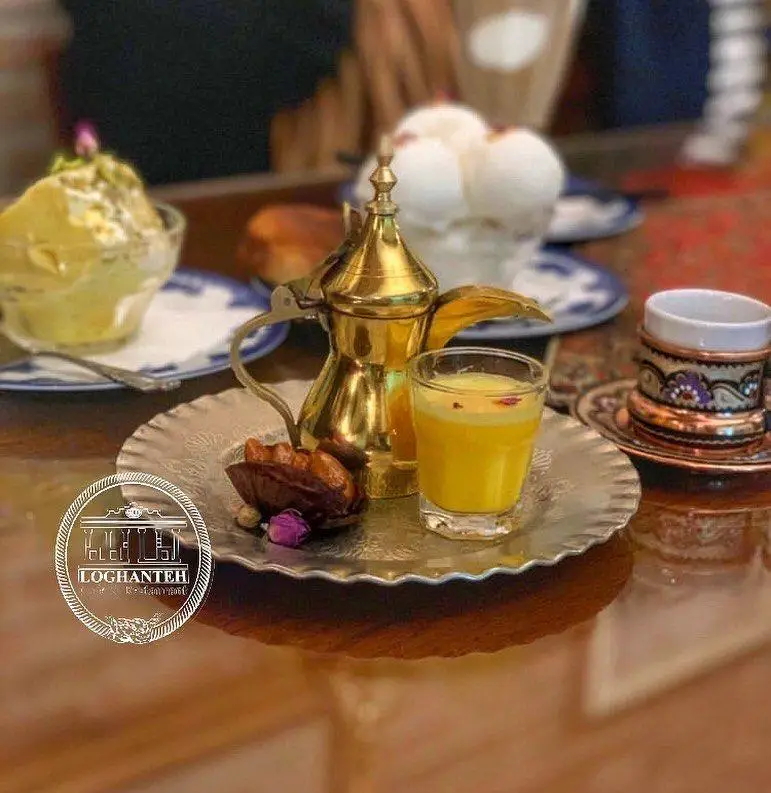 میز چوبی کافه لقانطه با دله قهوه سنتی، نوشیدنی اصیل زعفرانی، خرما و دسرهای شیک؛ لذت پذیرایی خاص ایرانی.