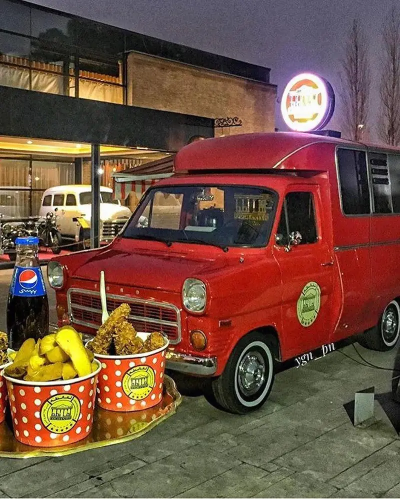 فودتراک جذاب کافه لقانطه با ون کلاسیک قرمز رنگ، سرو مرغ سوخاری و سیب‌زمینی داغ در فضای باز. یک تجربه غذای متفاوت و به یادماندنی.