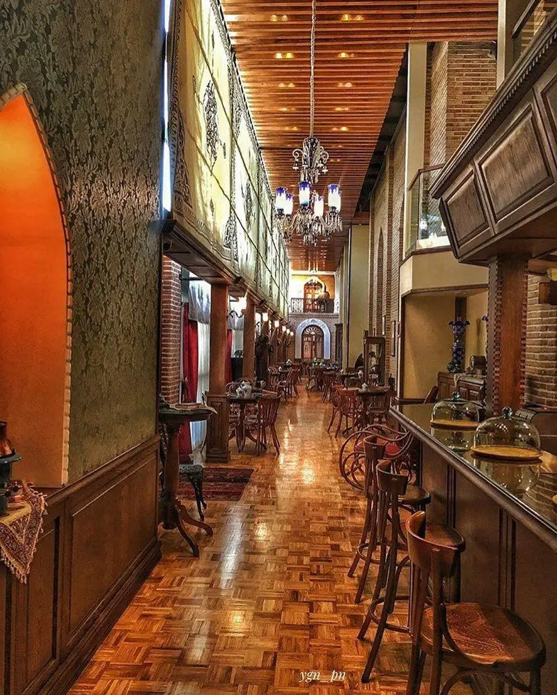 فضای داخلی چشم‌نواز کافه لقانطه، با دکوراسیون سنتی و چوبی، سقف و کفپوش پارکت. میز و صندلی‌های چوبی و باری دلنشین.