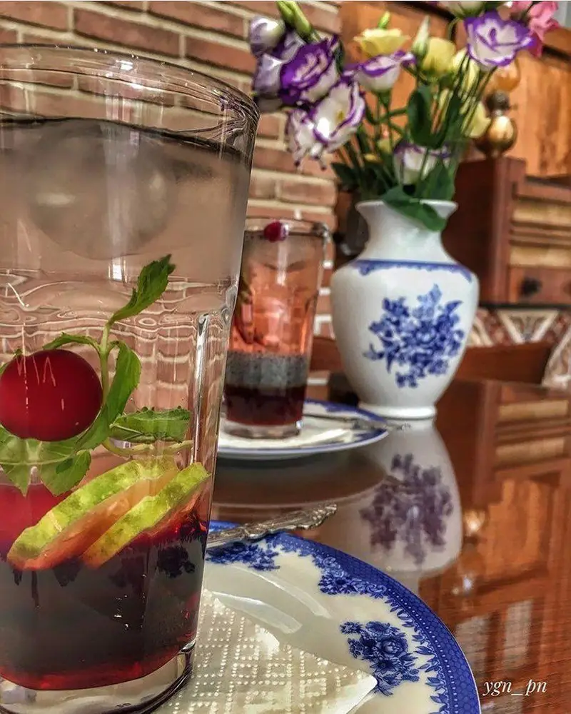 لذت نوشیدنی‌های خنک و دلنشین در محیط دنج و زیبای کافه لقانطه، همراه با گلدان گل و ظروف خاص برای ثبت خاطرات.