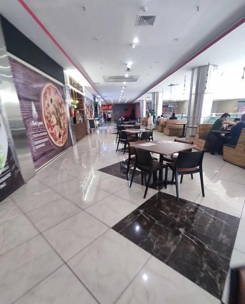 فضای داخلی دلنشین فودکورت و رستوران فست فود کاوان با چیدمان مدرن میز و صندلی‌ها، ایده‌آل برای صرف انواع پیتزا و غذاهای خوشمزه.