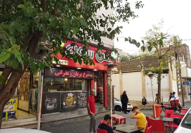 نمای بیرونی ساندویچ سن سون، فست فود محبوب تهران با منوی پیتزا، همبرگر و مرغ بریان زعفرانی و فضای غذاخوری در فضای باز.