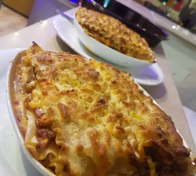 لازانیا داغ و لذیذ با سس مخصوص و رویه پنیر طلایی و پودر آویشن در چايخانه رهروان برای تجربه‌ای خوشمزه.