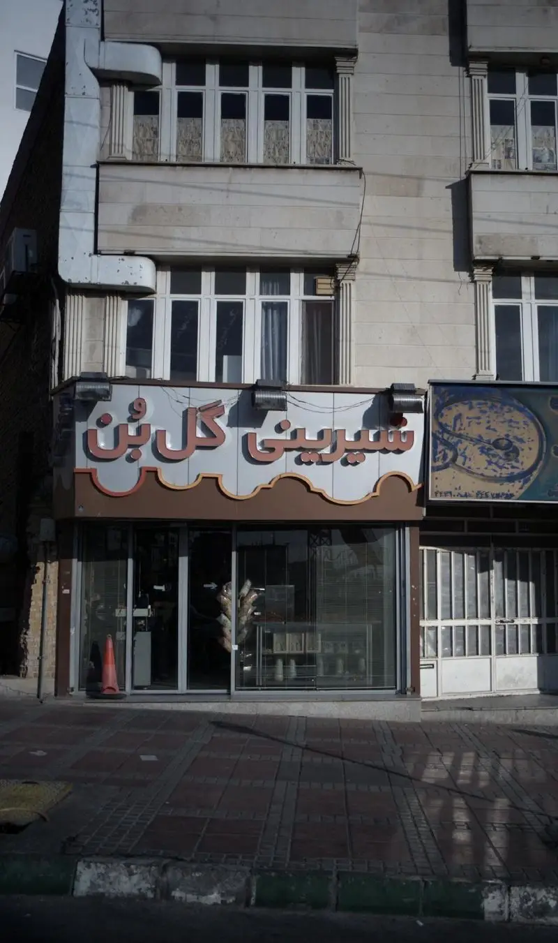 نمای بیرونی مغازه شیرینی گل بن، یک قنادی معتبر و محبوب با ویترین جذاب و محصولات تازه، واقع در خیابان.