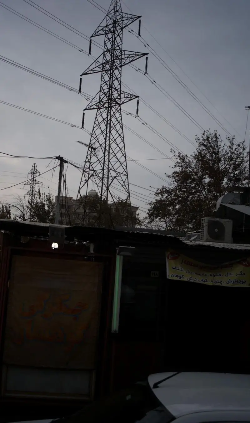 تصویری از نمای بیرونی جگرکی کوهسار، با بنر منوی کباب، جگر و جوجه ترش در محیط شهری و دکل برق فشار قوی.