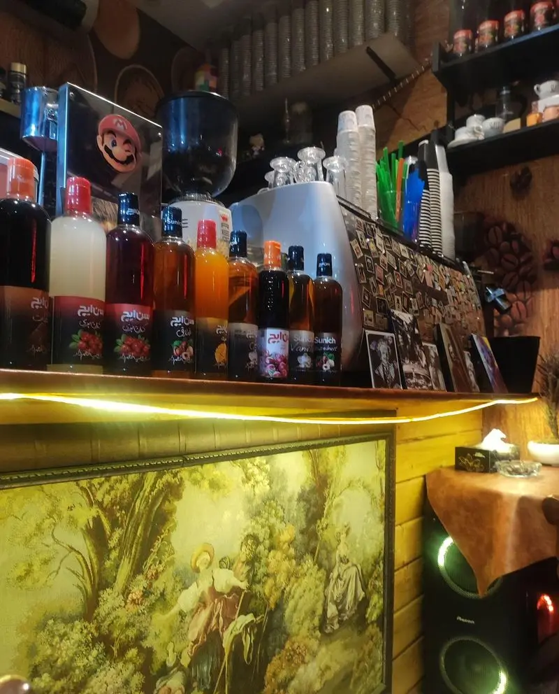 پیشخوان کافه تایم با انواع شربت و طعم دهنده های متنوع Sunich، دستگاه قهوه و لیوان های آماده برای تهیه قهوه و آبمیوه خوشمزه.