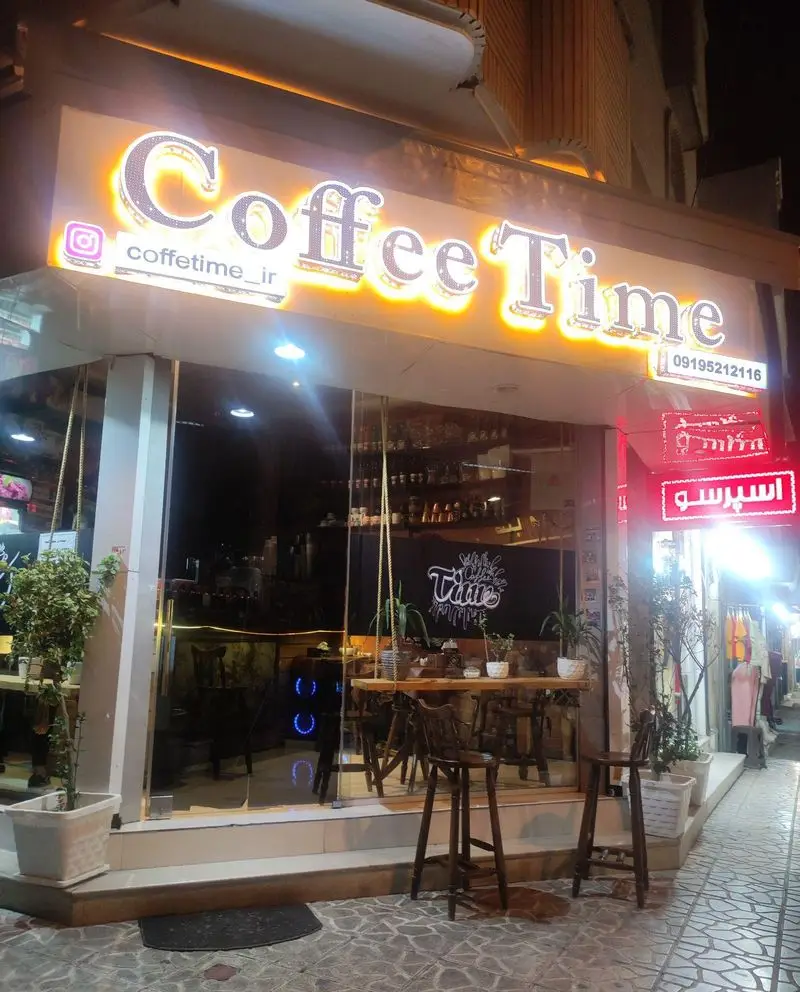 نمای بیرونی کافه تایم با تابلوی درخشان، نام اینستاگرام coffetime_ir، و شماره 09195212116، ارائه دهنده قهوه، آبمیوه و اسپرسو.