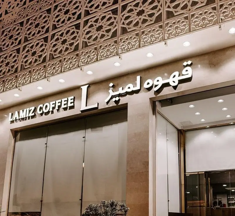 نمای بیرونی و تابلوی درخشان کافی شاپ قهوه لمیز شعبه پاسداران، فضایی دنج برای تجربه نوشیدنی‌های گرم در تهران.