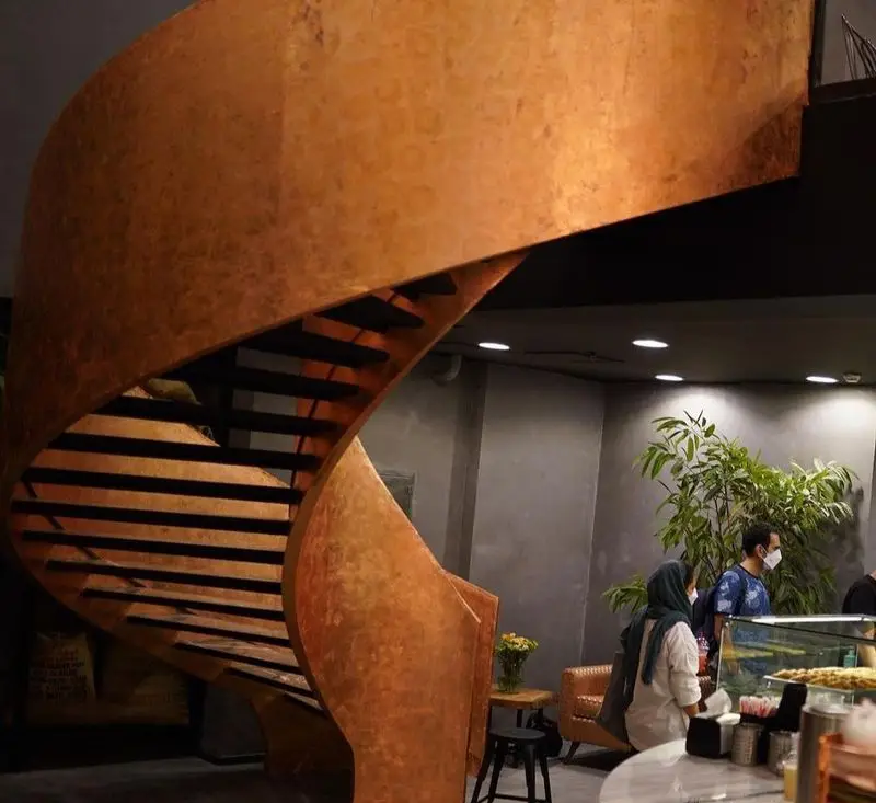 دکوراسیون داخلی مدرن کافی شاپ قهوه لمیز پاسداران با پلکان مارپیچ مسی و منحصربه‌فرد، فضایی دلنشین برای مشتریان