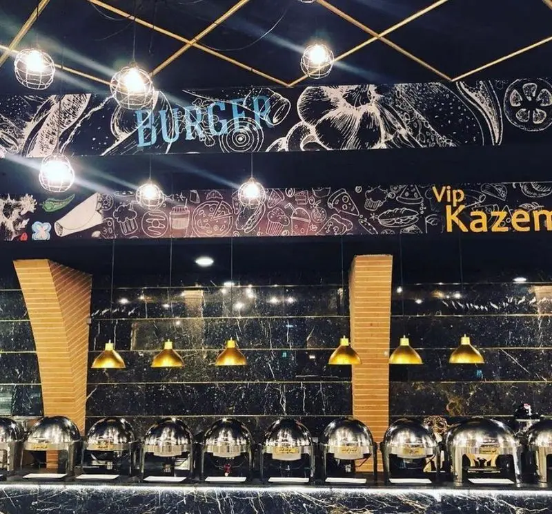 نمای داخلی رستوران وی آی پی کاظمی با بوفه سلف سرویس، غذاهای متنوع و دکوراسیون شیک و مدرن، مناسب برای تجربه غذایی لوکس.