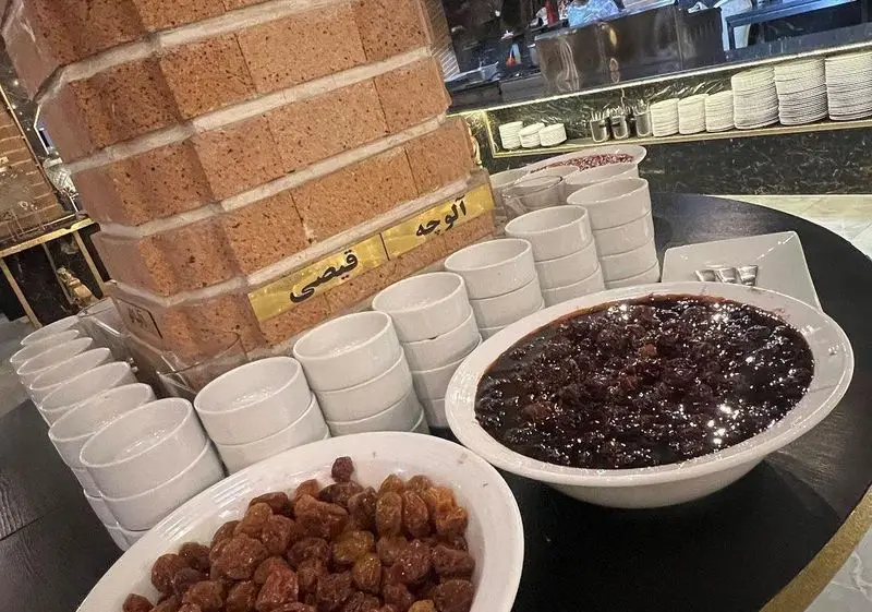 بوفه دسر و میوه‌های خشک شامل آلوچه، قیصی و کشمش در رستوران وی آی پی کاظمی با ظروف چینی مرتب و آماده سرو.