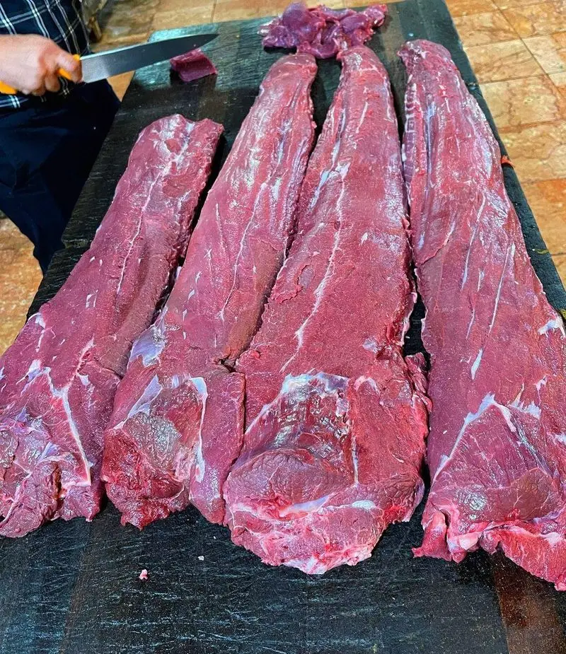 آماده‌سازی دقیق گوشت تازه و باکیفیت فیله برای تهیه غذاهای لذیذ در رستوران وی آی پی کاظمی توسط قصاب حرفه‌ای.