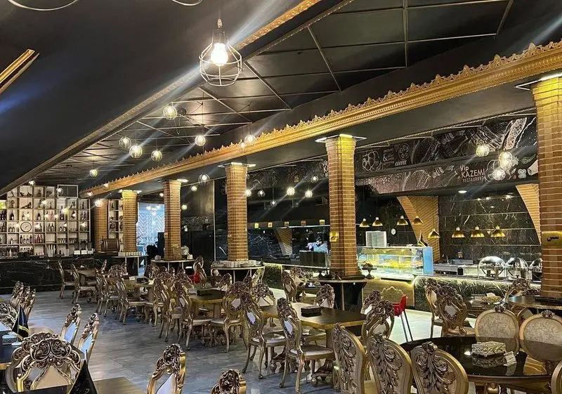 فضای داخلی لوکس رستوران وی آی پی کاظمی با دکوراسیون مجلل، میز و صندلی‌های طلایی و بار نوشیدنی. مناسب برای تجربه غذایی دلنشین.