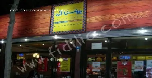 نمای شبانه رستوران پیتزا آرد با تابلوی روشن و سردر چوبی، آماده سرو فست فود و پیتزاهای خوشمزه به مشتریان