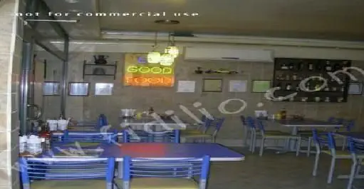 تصویر فضای داخلی دنج و مدرن رستوران پیتزا آرد با چیدمان مرتب میز و صندلی‌های آبی، ایده‌آل برای سرو انواع پیتزا و غذاهای فست‌فود.