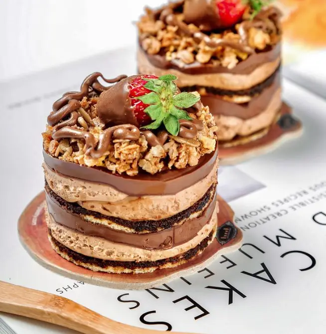 دو مینی کیک شکلاتی لایه ای بوتیک نان و شیرینی بانش با روکش گاناش، توت فرنگی و گرانولا؛ دسری خوشمزه و خاص.