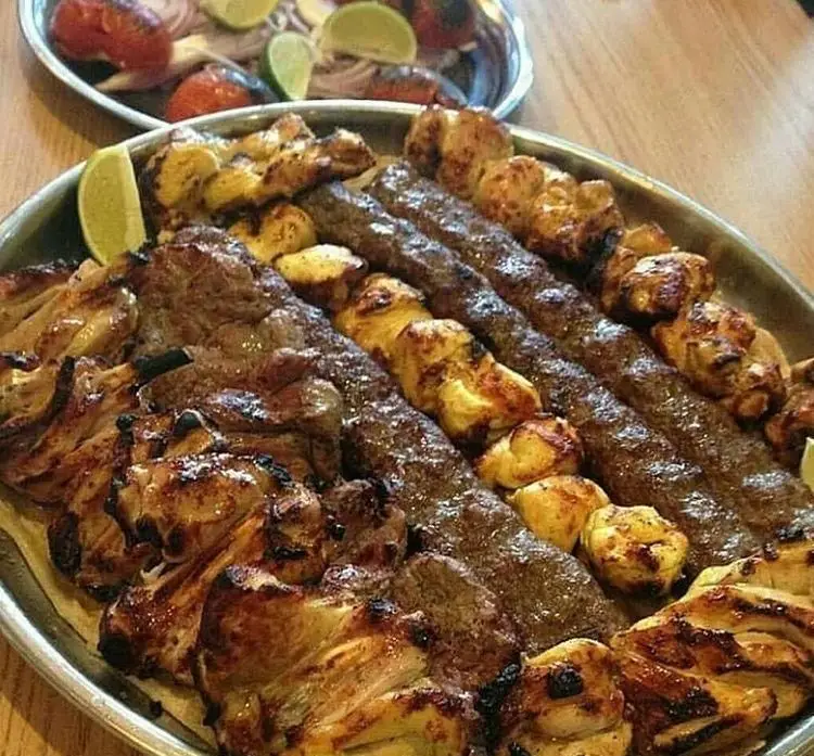 سینی مجلل و اشتهاآور انواع کباب‌های چلوکبابی چشم بین: کباب کوبیده، جوجه و برگ گوشت. یک ضیافت لذیذ غذای سنتی ایرانی.