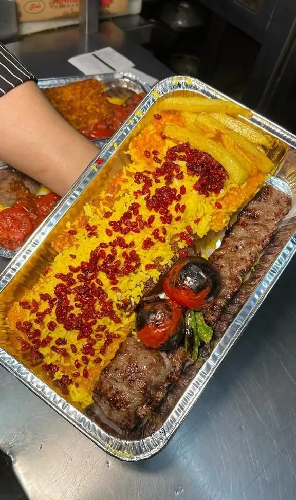 یک سینی بزرگ چلوکباب کوبیده و برگ به همراه زرشک پلو، سیب زمینی و گوجه کبابی از کترینگ سید جلال. کیفیت برتر غذای ایرانی.