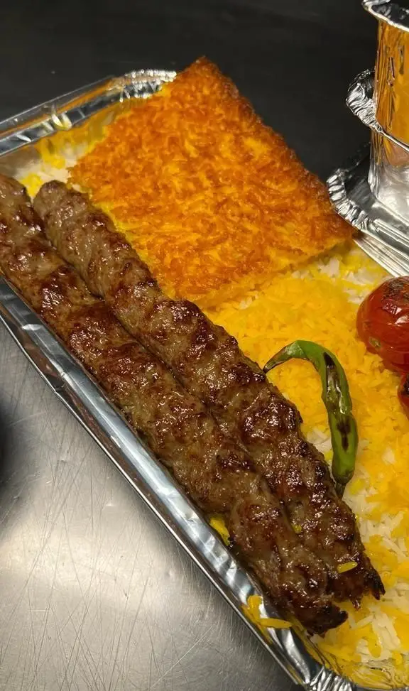 کباب کوبیده خوش طعم به همراه برنج زعفرانی و ته دیگ ترد، غذای اصیل ایرانی از کترینگ سید جلال. مناسب سفارش و مجالس.