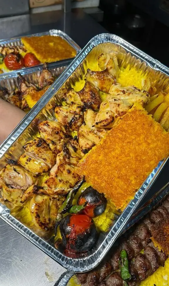 ظروف غذای کترینگ سید جلال حاوی جوجه کباب، کباب کوبیده، برنج زعفرانی، ته دیگ طلایی و گوجه کبابی تازه برای بیرون بر.