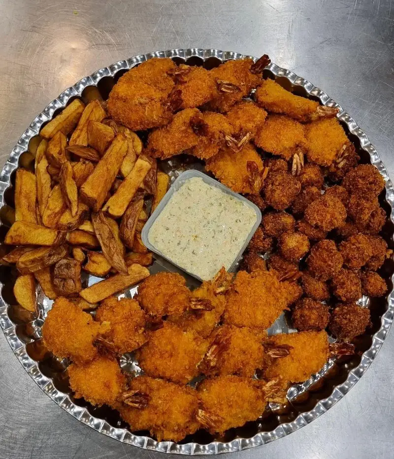 بشقاب لذیذ میگو سوخاری ترد و سیب زمینی سرخ کرده با سس مخصوص رستوران شمشیری، انتخابی عالی برای دوستداران غذای دریایی.