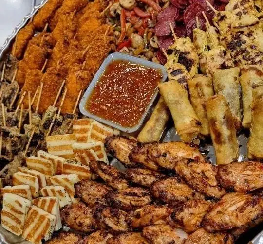 سینی بزرگ مزه رستوران شمشیری شامل بال مرغ، جوجه چینی، اسپرینگ رول، مکعب‌های پنیر و سس مخصوص.