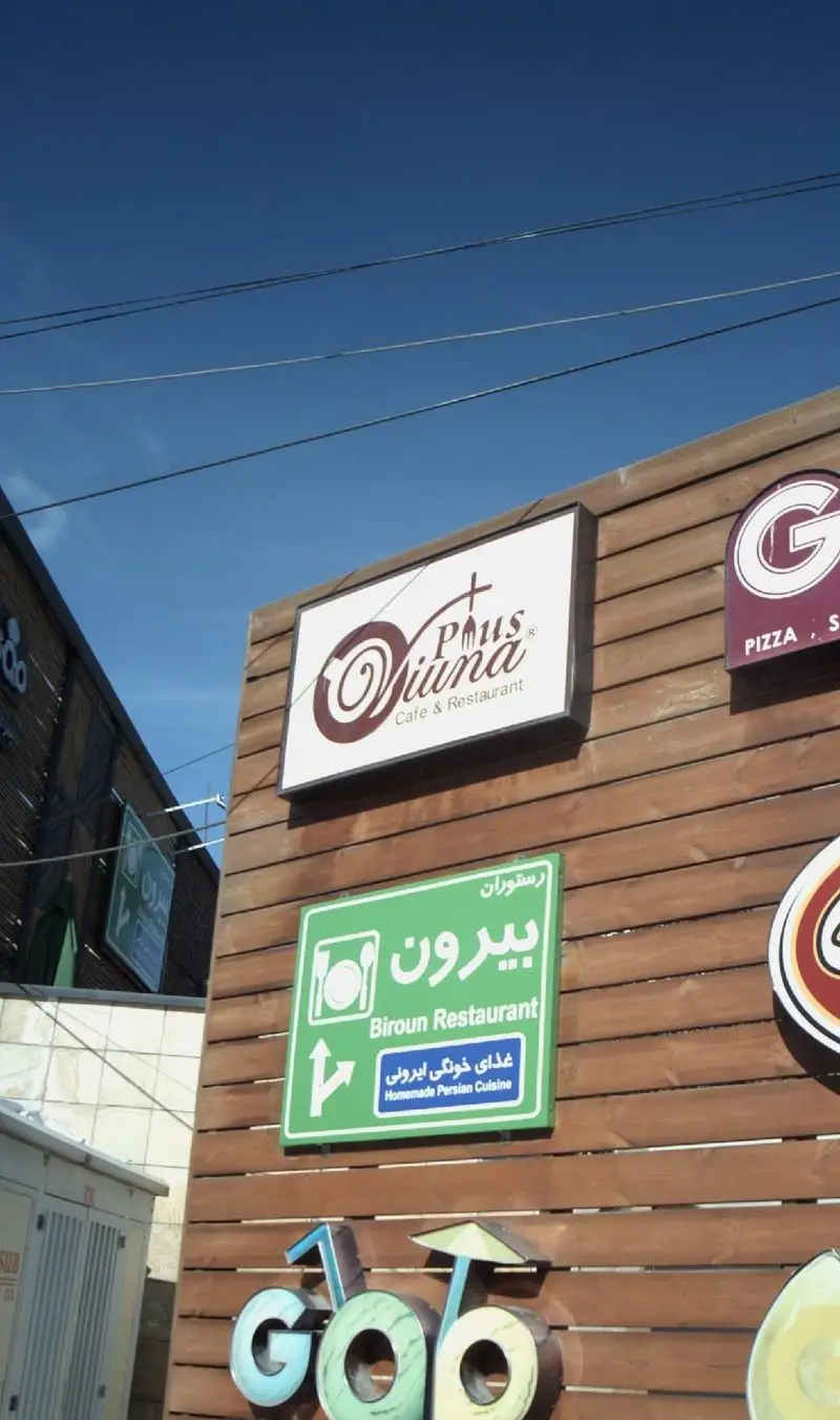 نمای بیرونی کافه رستوران ویونا پلاس با تابلوی اصلی و تابلوی رستوران بیرونی که غذای خانگی ایرانی ارائه می‌دهد.