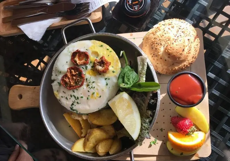 صبحانه کامل در کافه رستوران ویونا پلاس: تخم مرغ، سیب زمینی، نان کنجدی، میوه و سبزیجات تازه، ایده‌آل برای شروع روزی پرانرژی.