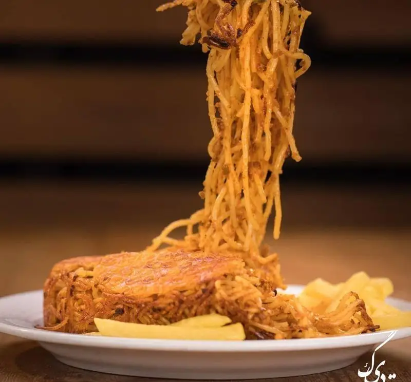 پاستا ته دیگی طلایی و ترد رستوران ته دیگ در حال سرو شدن؛ یک غذای ماکارونی لذیذ و متفاوت با بافتی برشته و طعمی فراموش‌نشدنی.