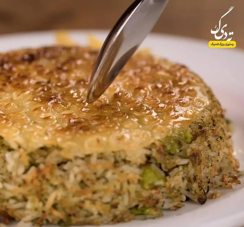 ته دیگ طلایی و ترد برنج، غذای اصیل ایرانی از رستوران بزرگ ته دیگ. نمایی نزدیک از یک ته دیگ خوشمزه با برنج مخلوط آماده سرو.