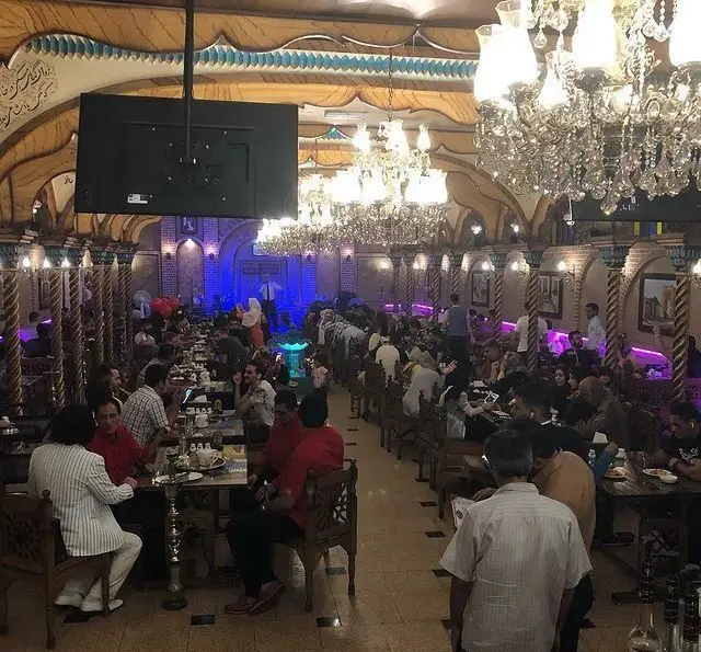 رستوران سنتی یادگاری: نمایی از سالن بزرگ و پر از مشتری با دکوراسیون سنتی ایرانی، لوسترها و محیطی دلنشین برای صرف غذا و دورهمی.